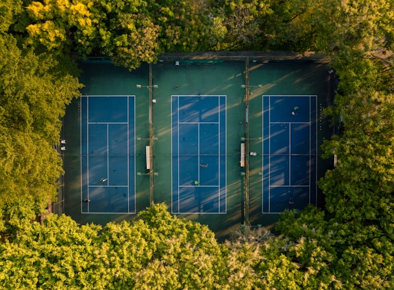 A lively tennis court with players engaged in a match under a clear blue sky.