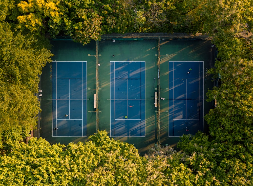 an aerial view of a tennis court surrounded by trees