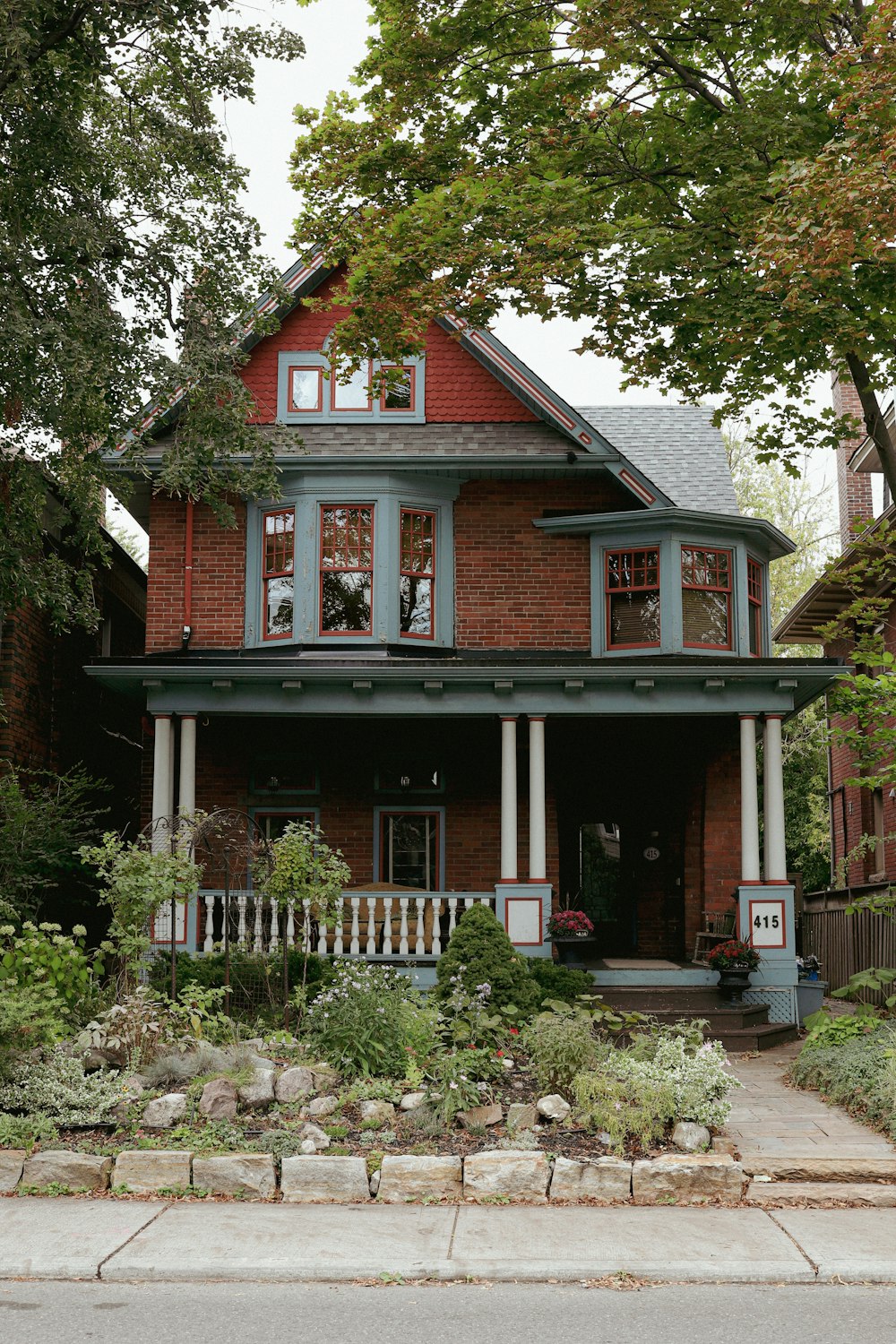a red brick house with a large front porch