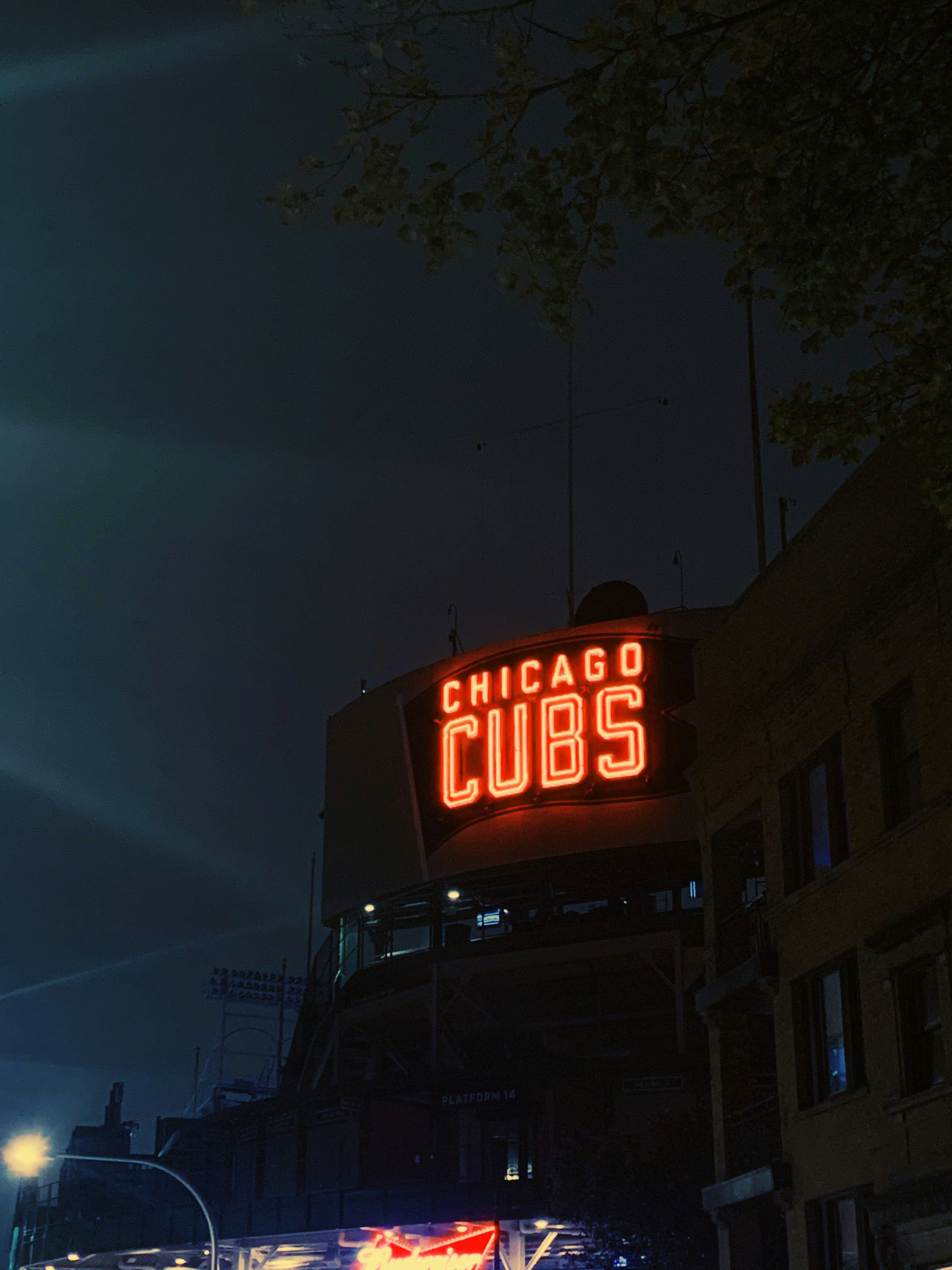 the chicago cubs sign is lit up at night