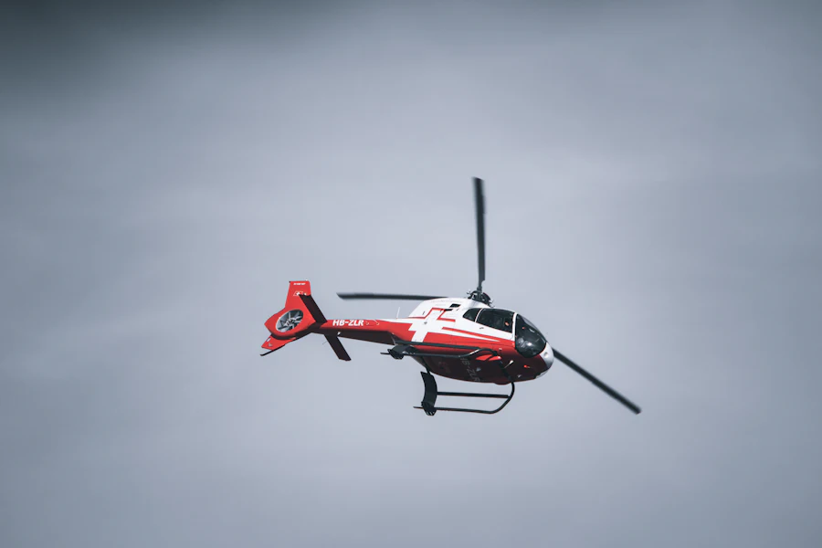 A red and white twin-engine helicopter turning in open sky
