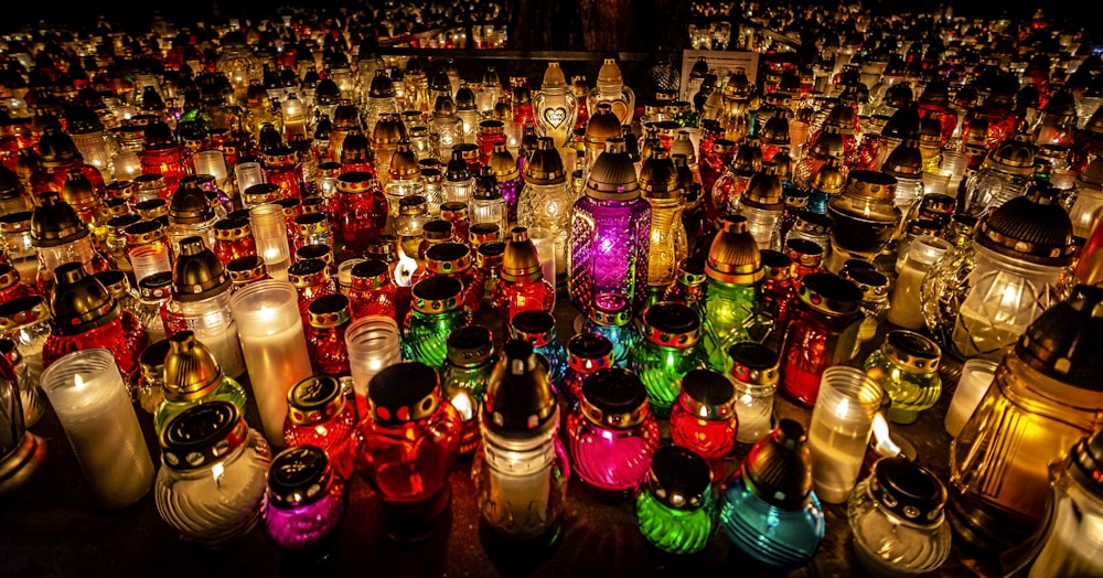 um grande grupo de velas coloridas acesas sentadas em cima de uma mesa