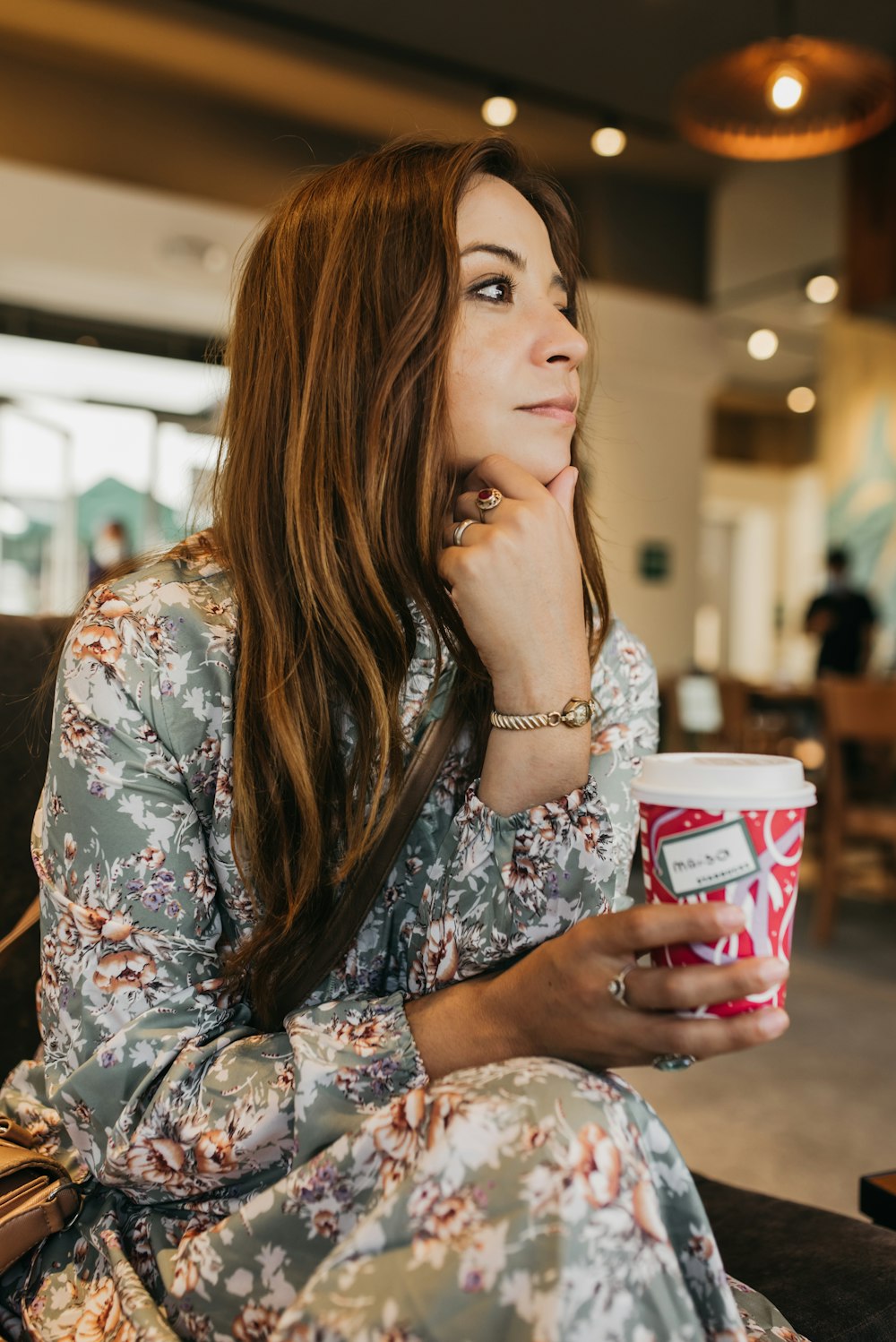 a woman sitting on a couch holding a cup of coffee