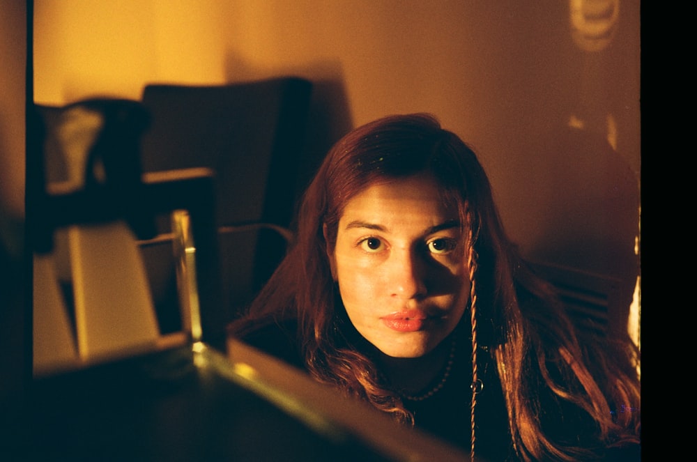 a woman with long red hair looking at the camera