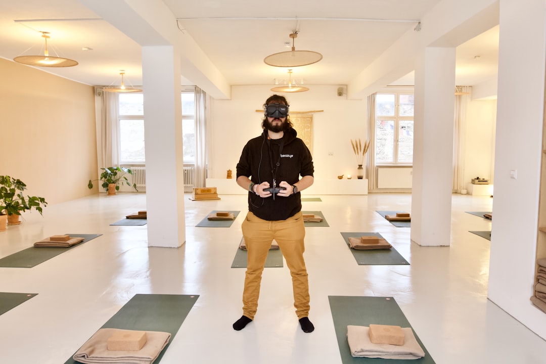 a man standing on a yoga mat in a room, FPV drone pilot shooting an indoor real estate videos in one of the Beazy film l