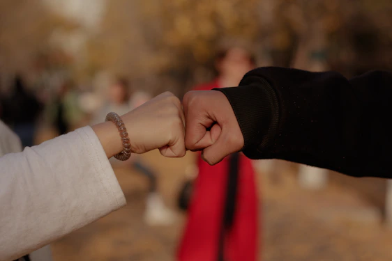 a close up of two people holding hands