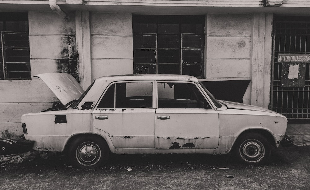 an old car parked in front of a building