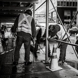 a group of men standing next to each other on a sidewalk