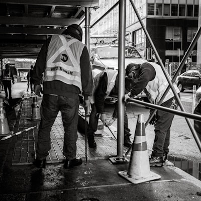 a group of men standing next to each other on a sidewalk