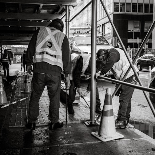 a group of men standing next to each other on a sidewalk