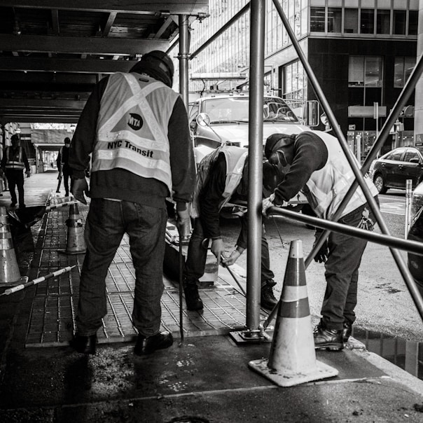 a group of men standing next to each other on a sidewalk