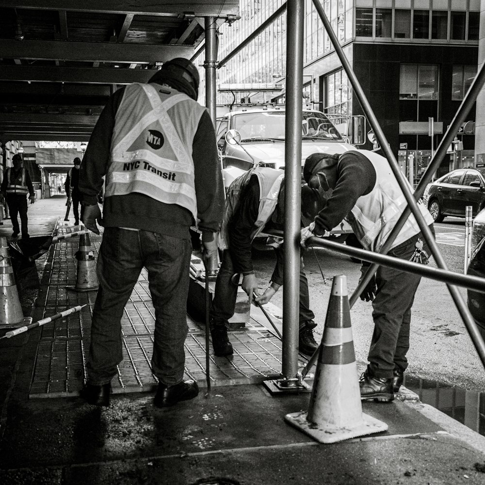 a group of men standing next to each other on a sidewalk