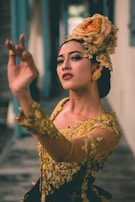 a woman wearing a yellow dress and a flower in her hair