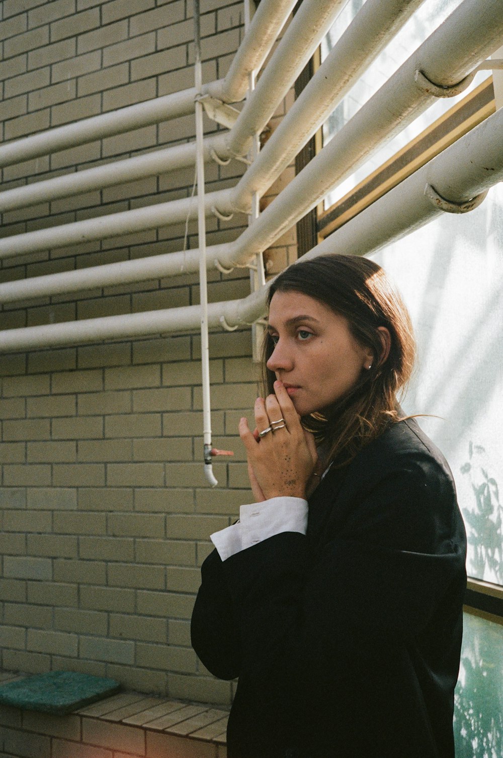 a woman smoking a cigarette in front of a window