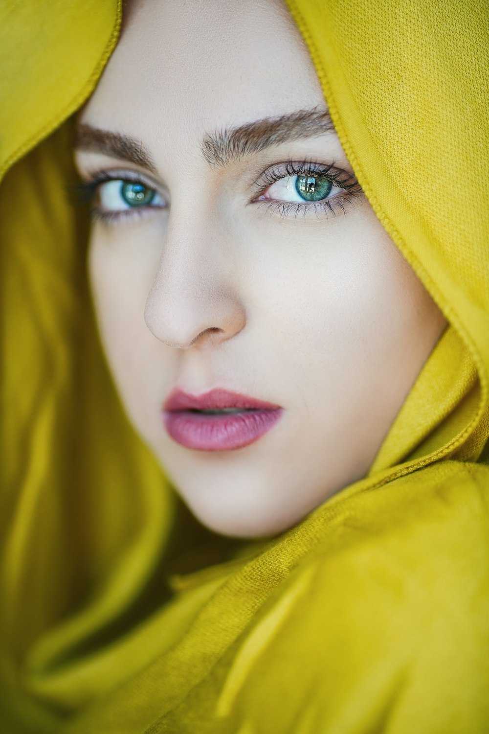 a woman with blue eyes wearing a yellow shawl