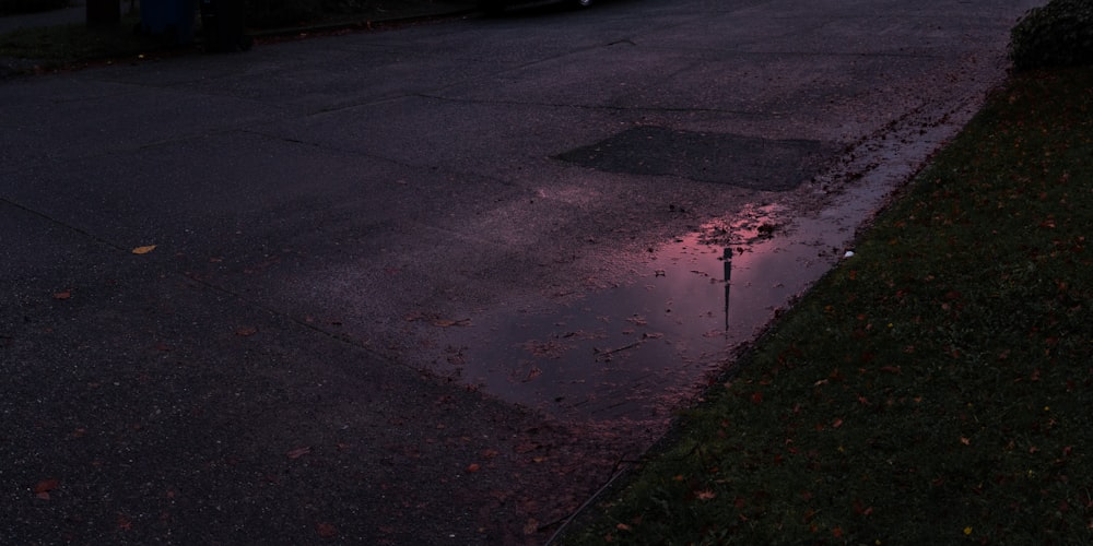 a puddle of water on the side of a road