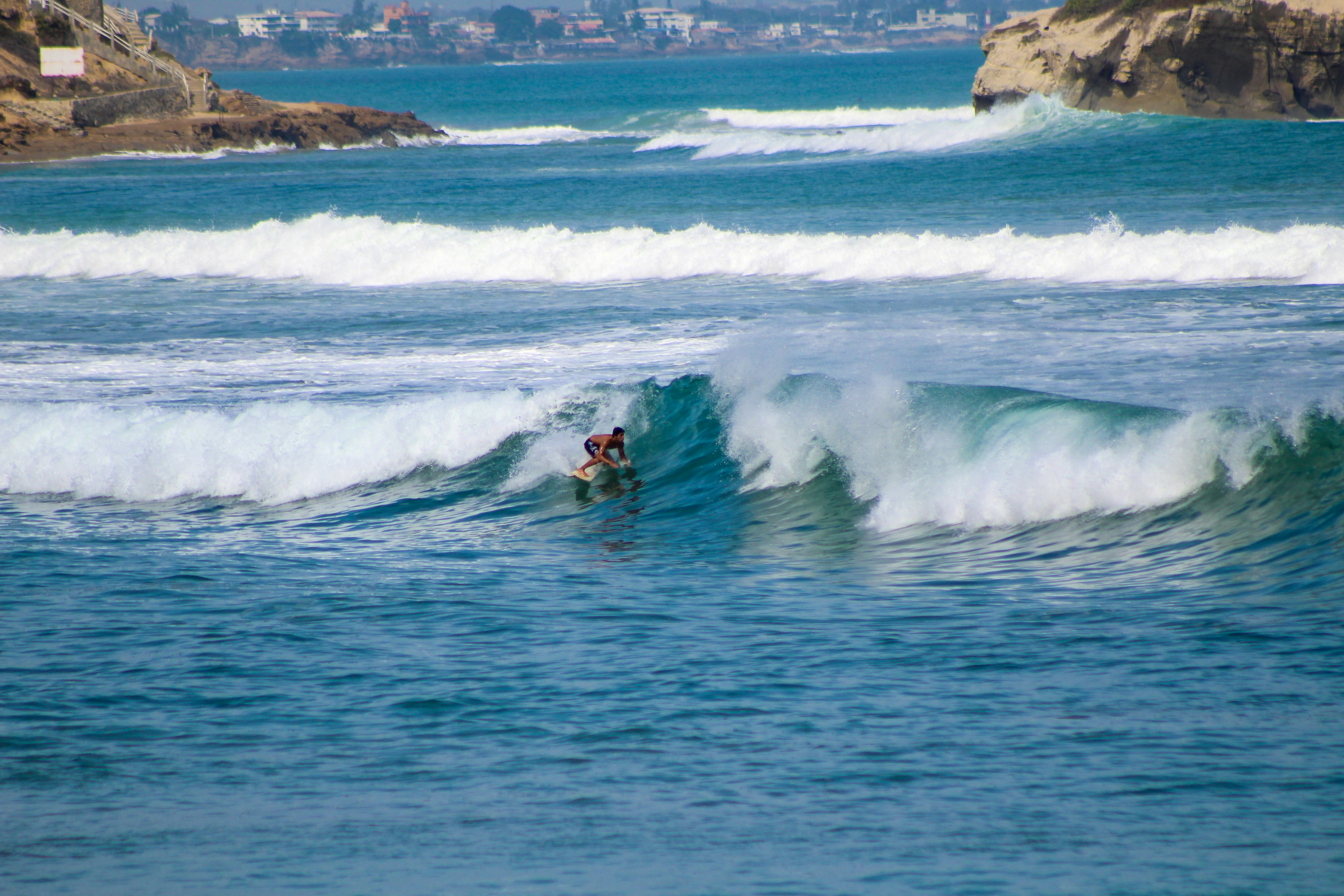 a man riding a wave on top of a surfboard, 