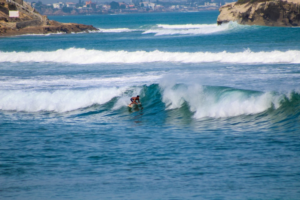 a man riding a wave on top of a surfboard