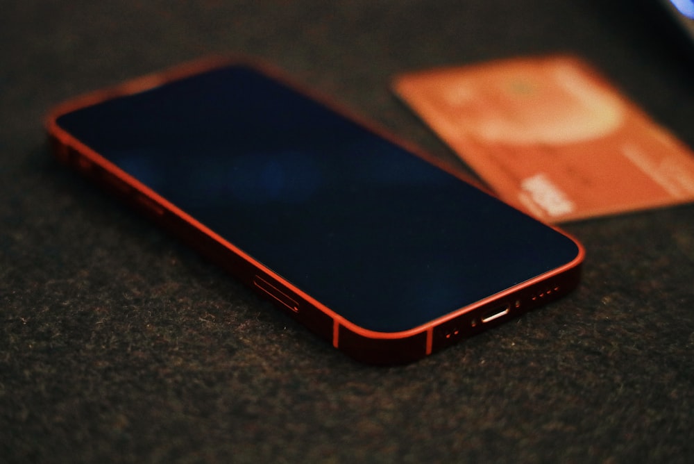 a close up of a cell phone near a credit card