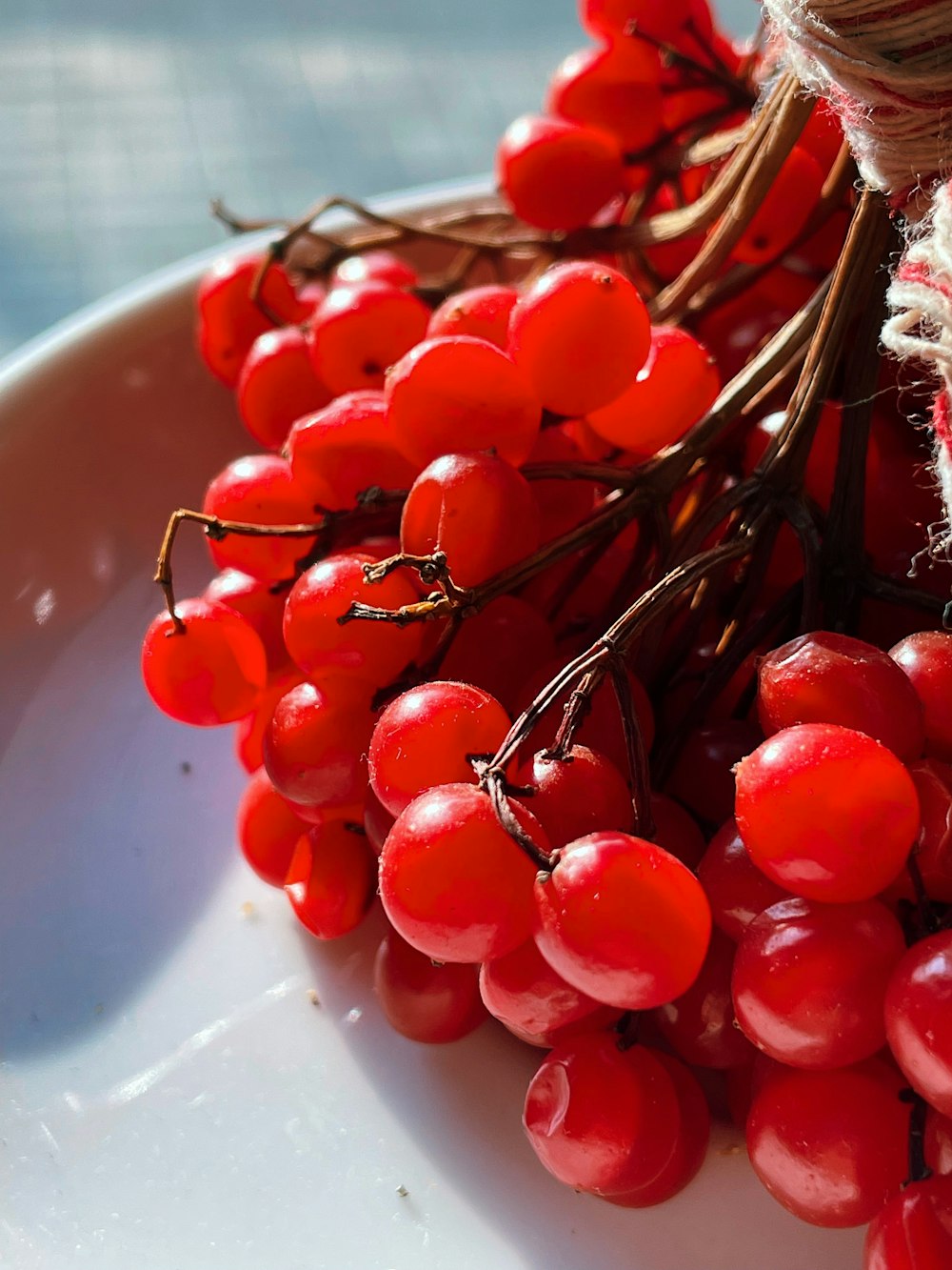 a white bowl filled with red berries on top of a table