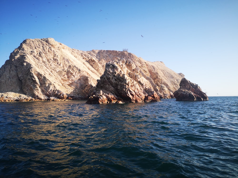 a large rock formation in the middle of a body of water