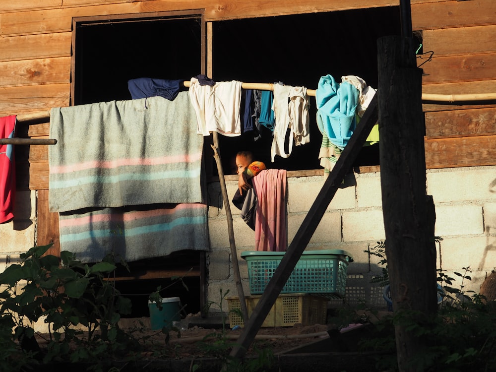 a woman standing in a window of a wooden building