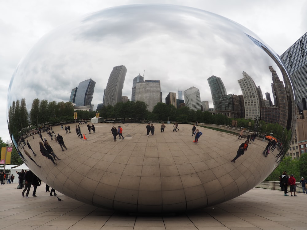 a large mirror ball sitting in the middle of a park