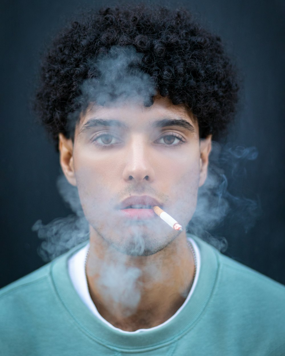 a man with an afro smoking a cigarette