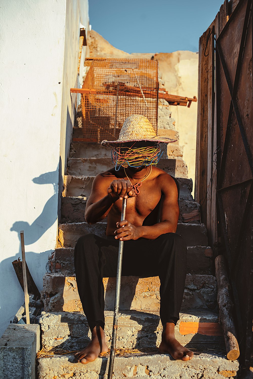 a man with a straw hat sitting on some steps