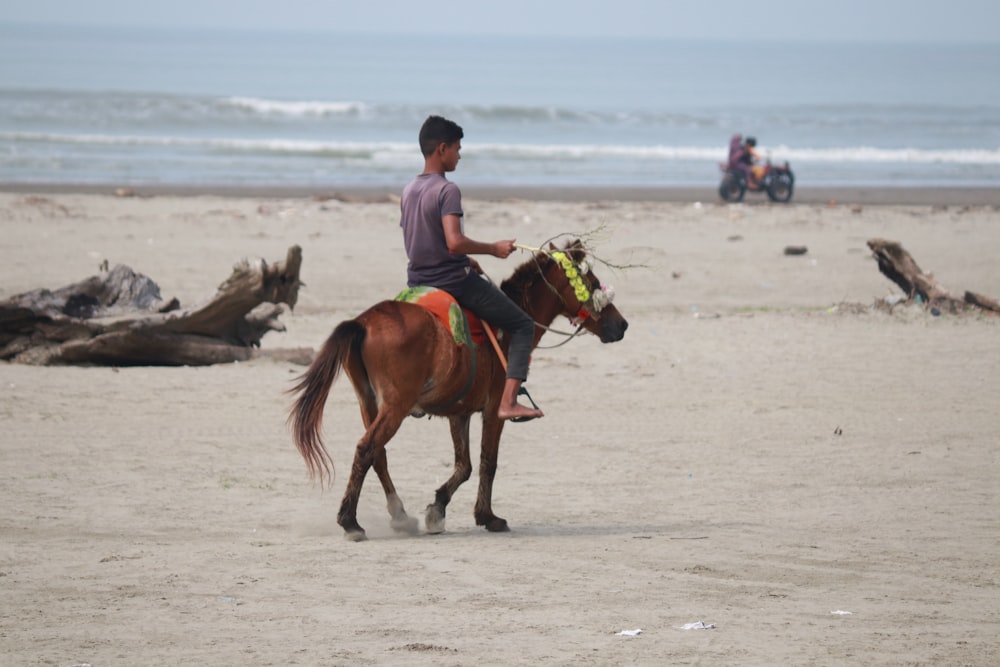 a man riding a horse on the beach