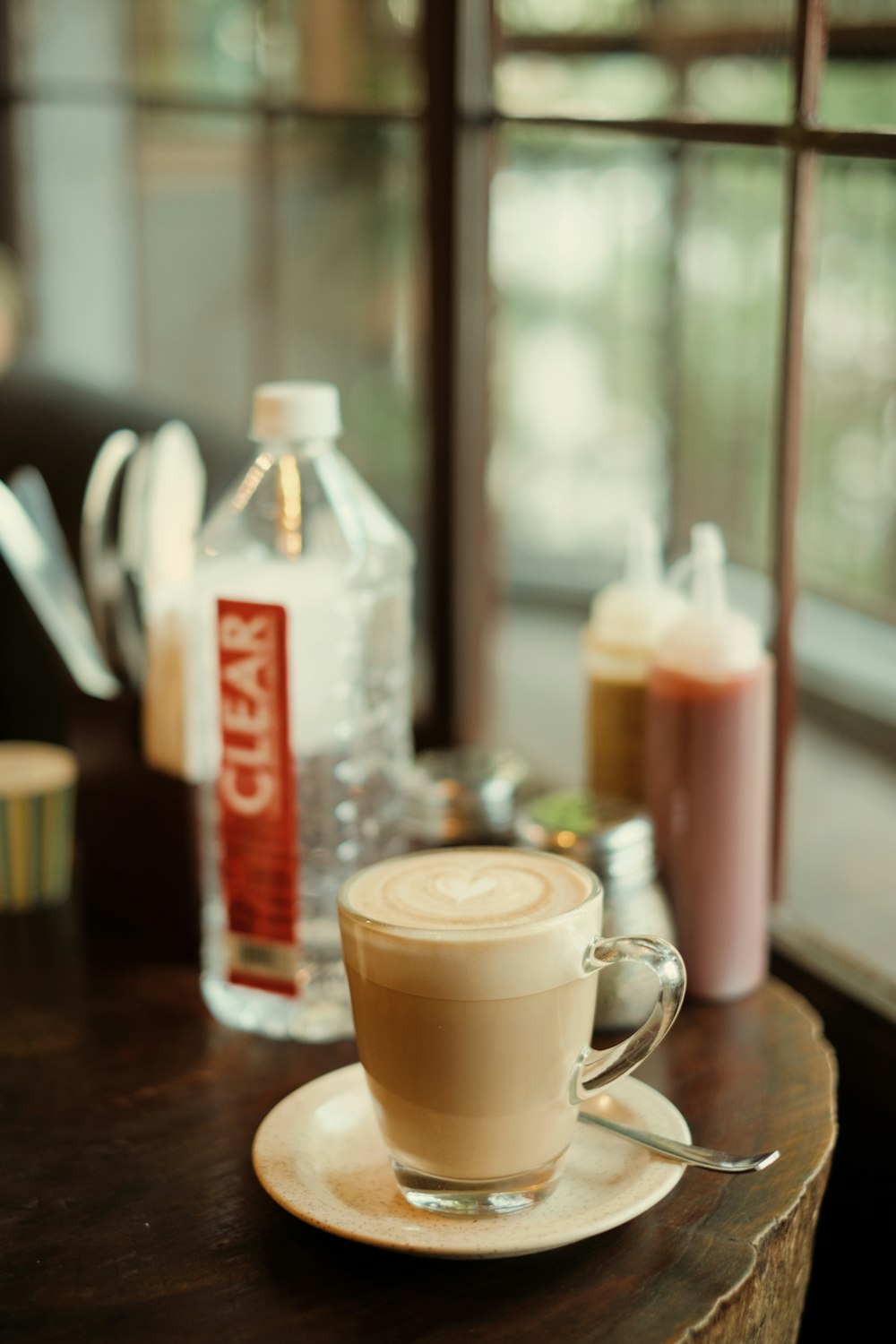 a cappuccino sits on a saucer on a table