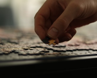 a person placing a piece of a puzzle together
