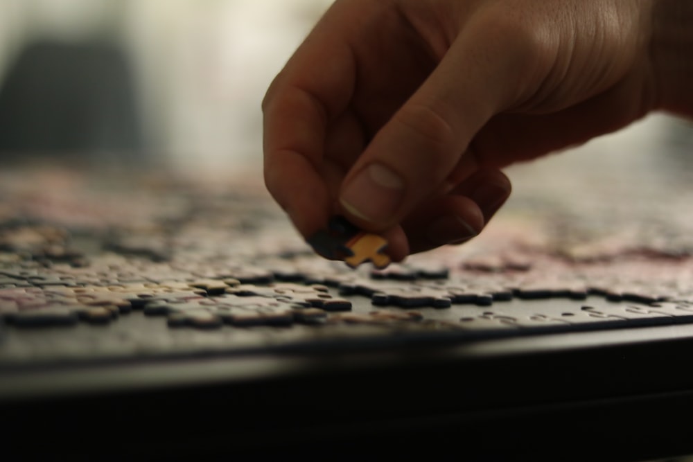 a person placing a piece of a puzzle together