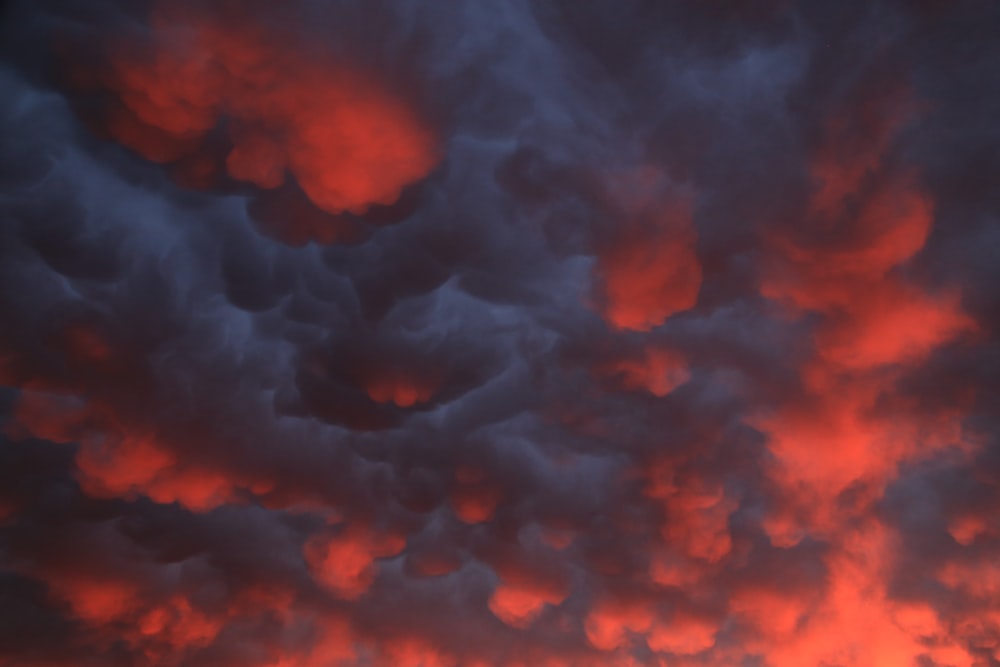 a red and blue sky with clouds in the background