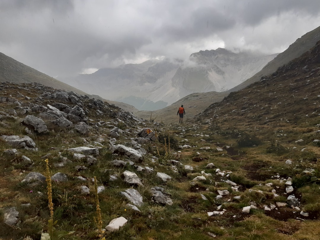 a man hiking up a mountain in the rain,