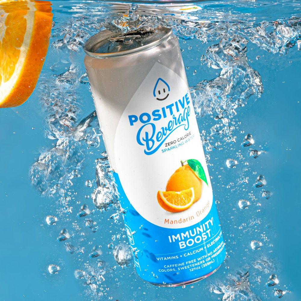 a can of orange juice floating in a pool of water