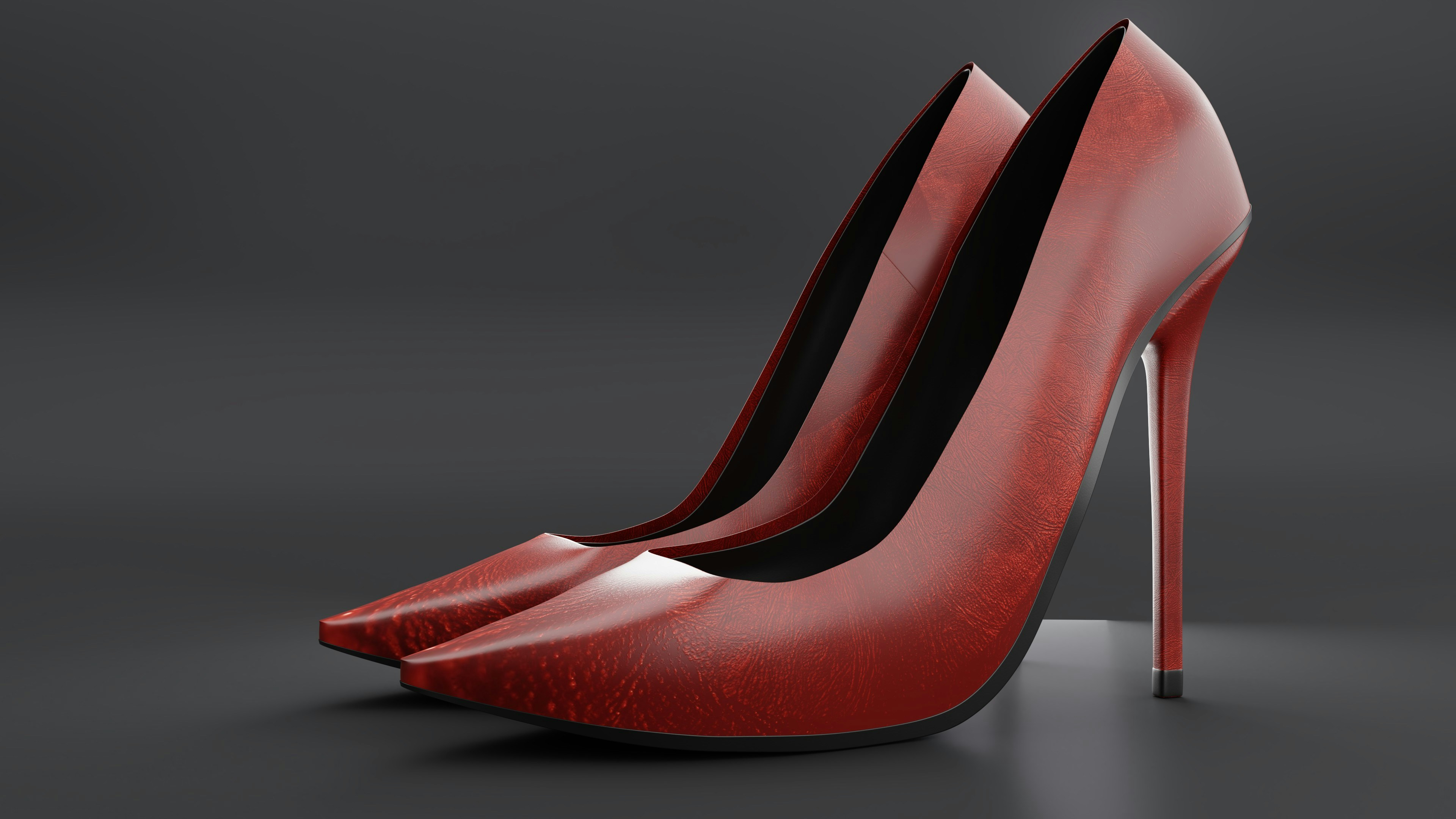 a pair of red high heeled shoes on a grey background