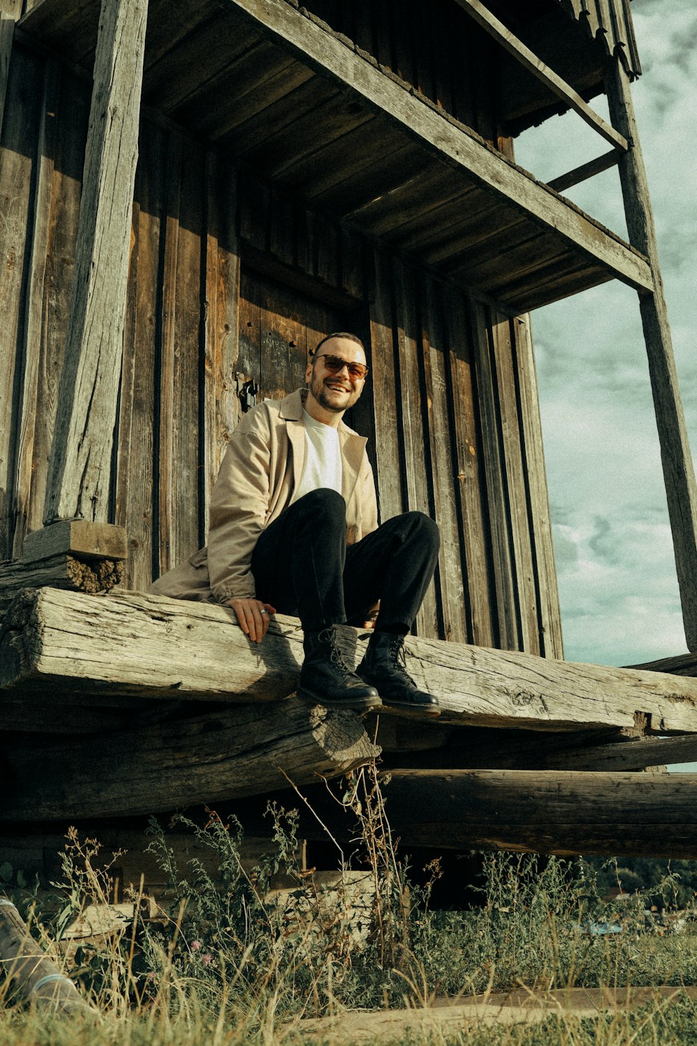 a man sitting on a log in front of a building