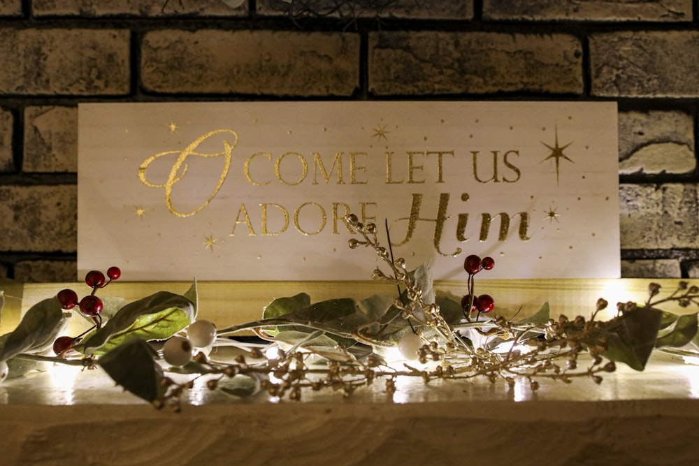 a wooden sign that says, come let us adore him