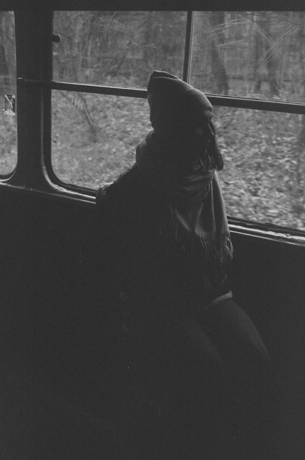 a black and white photo of a person on a bus