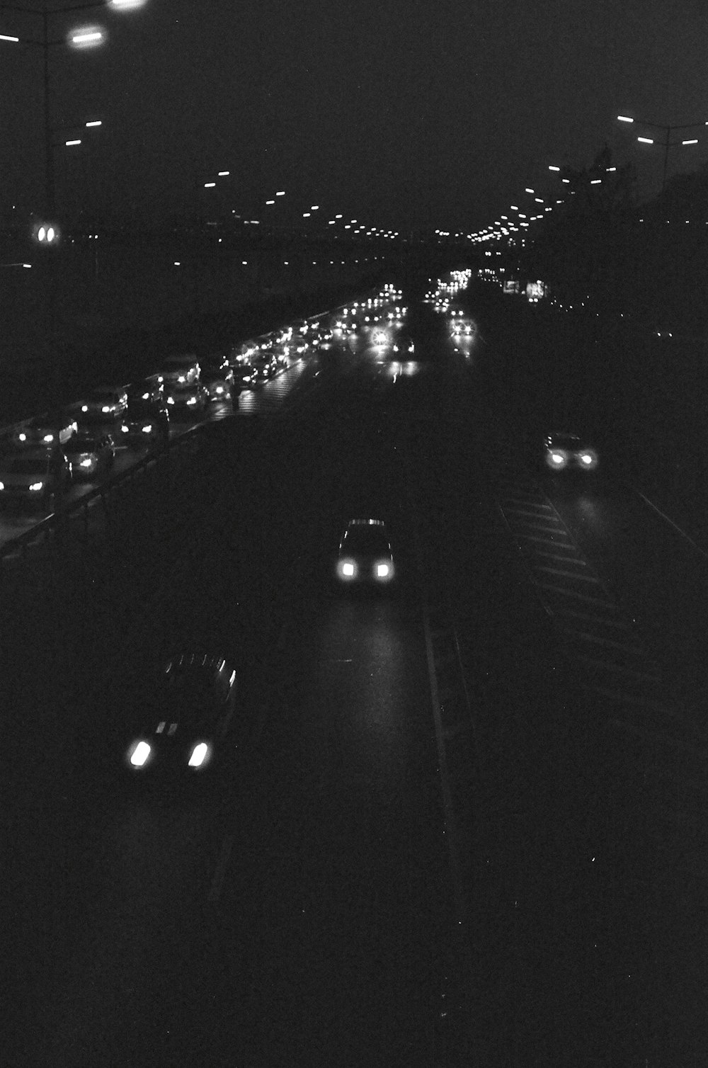 a black and white photo of a highway at night