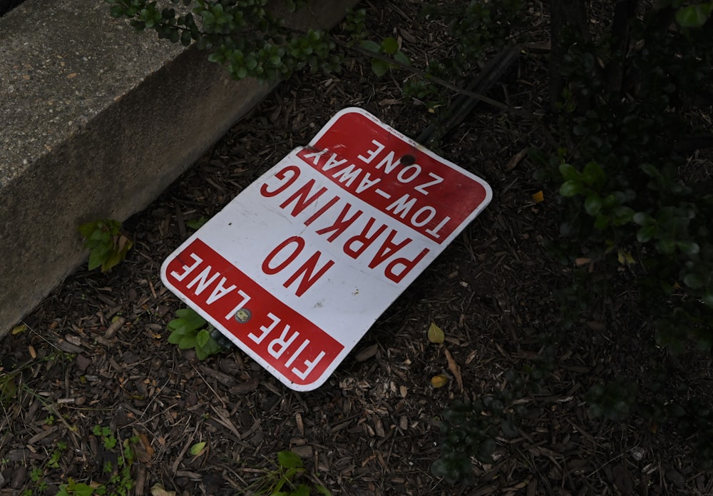 a red and white sign sitting on the ground