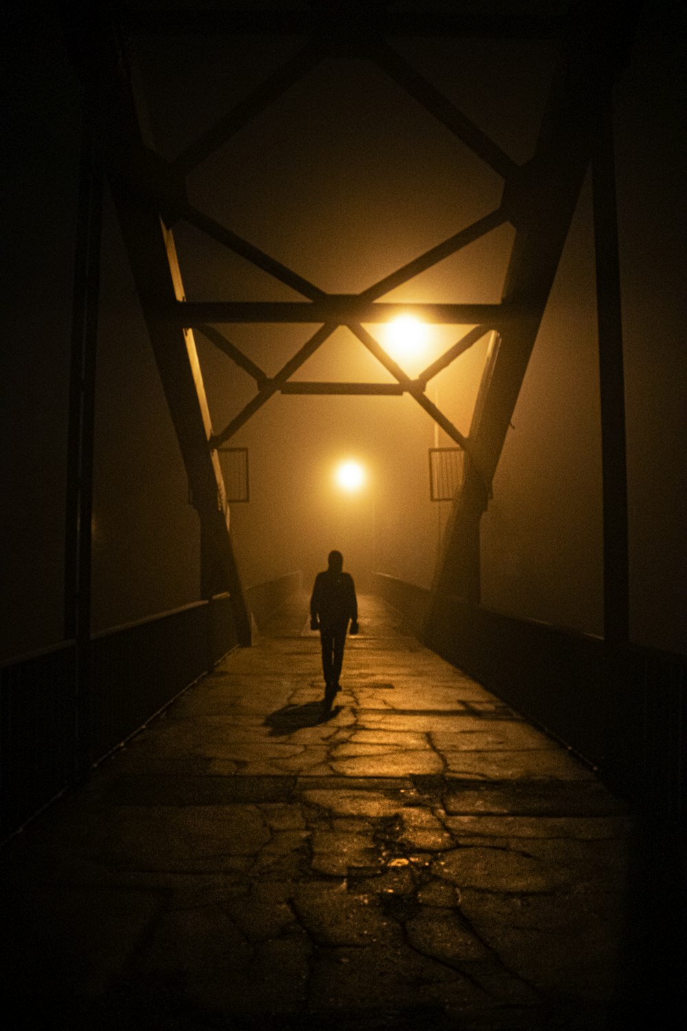 a person walking down a walkway at night