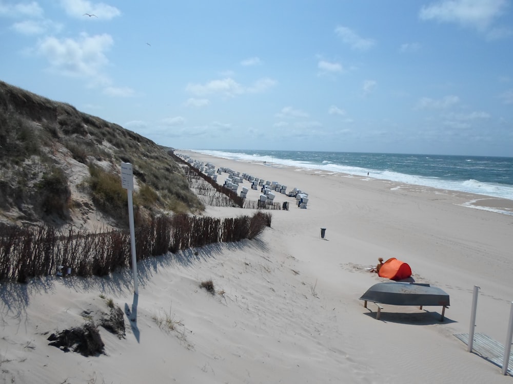 une rangée de chaises de plage assises au sommet d’une plage de sable