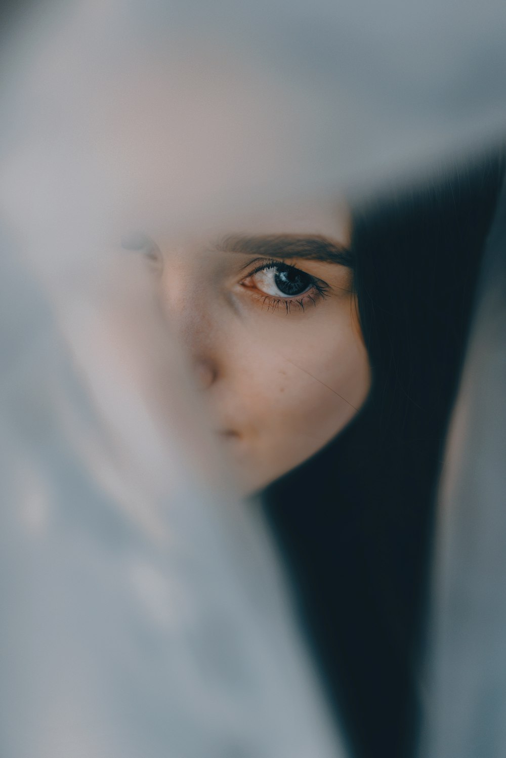 a close up of a person's face through a curtain