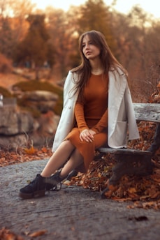 a woman sitting on a bench in a park