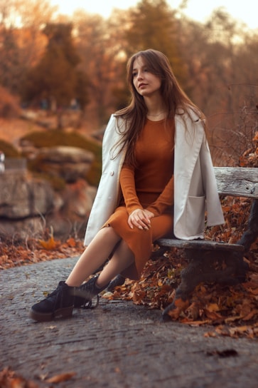 a woman sitting on a bench in a park