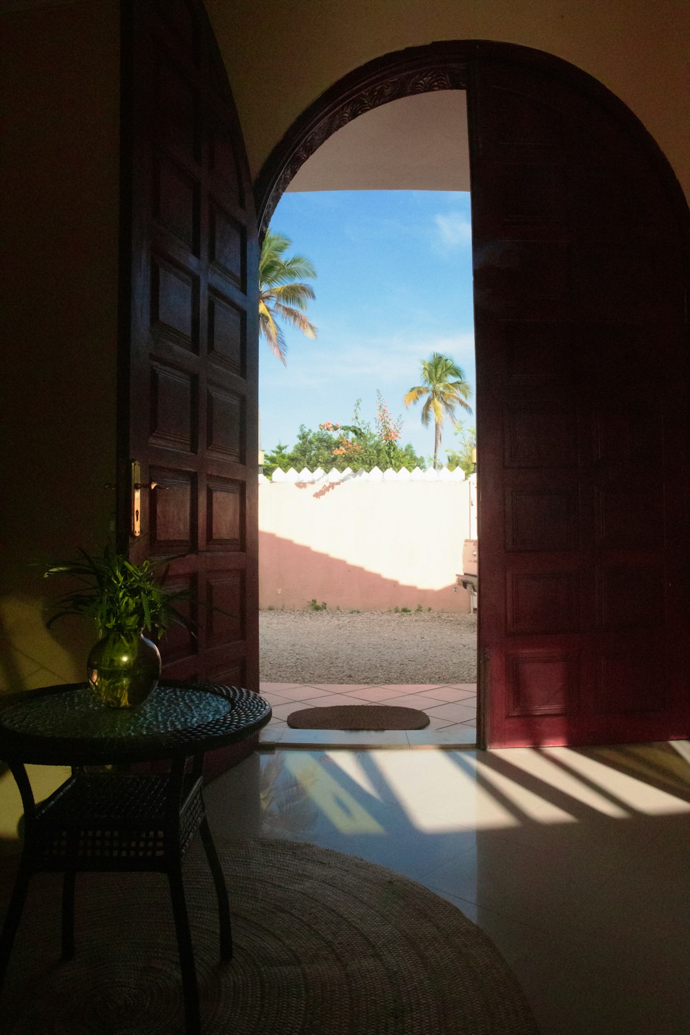 an open door leading to a patio with a table and chairs