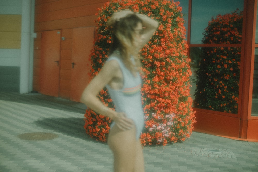 a woman in a white swimsuit standing in front of a building