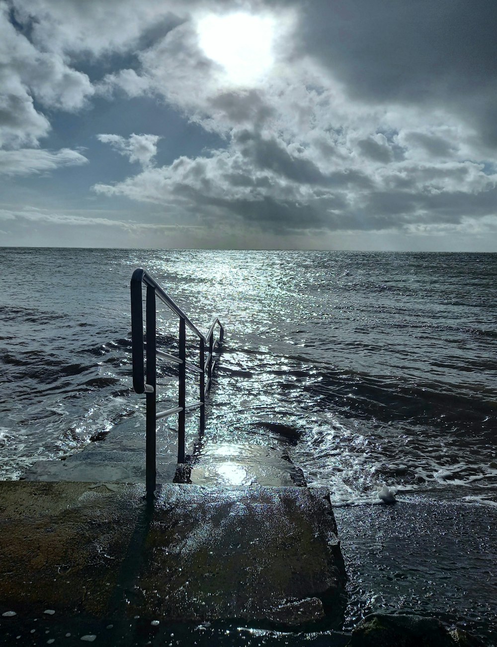 o sol brilha através das nuvens sobre o oceano